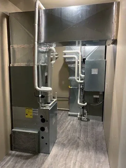 HVAC system in a narrow hallway. Ductwork, furnace, and related components visible.