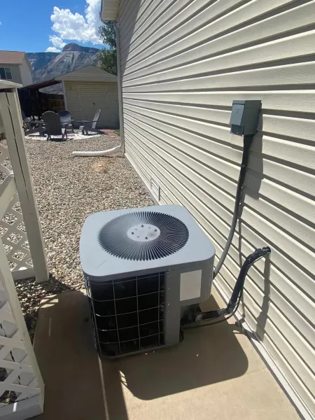 A construction worker wearing a blue hard hat is working on a roof