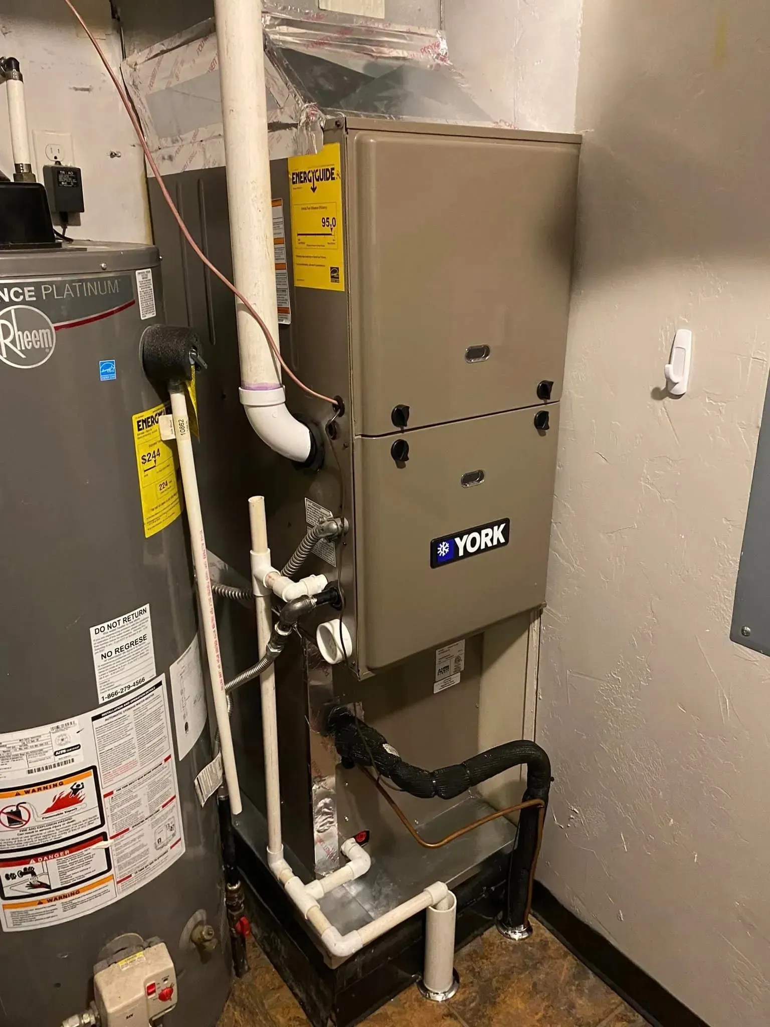 A York furnace and a water heater installed in a utility room.