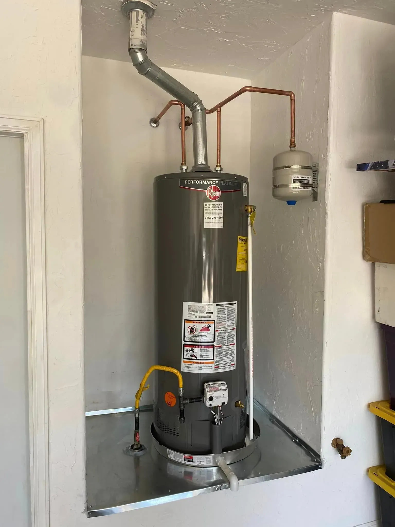 A water heater installed in a recessed space; includes venting, piping, and expansion tank.