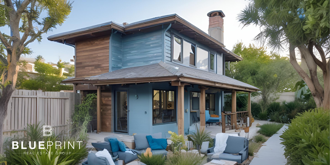 A patio with a lot of furniture and plants in front of a house.