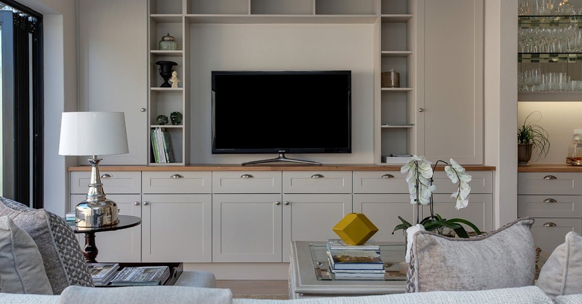 A living room with a couch and a flat screen tv on the wall.