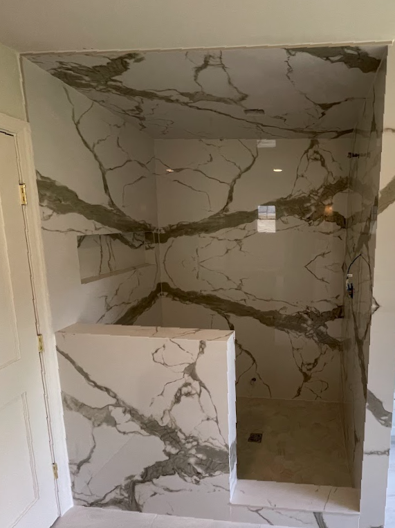 A kitchen with black cabinets and white counter tops.