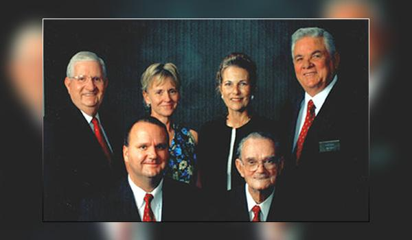 A group of men and women are posing for a picture