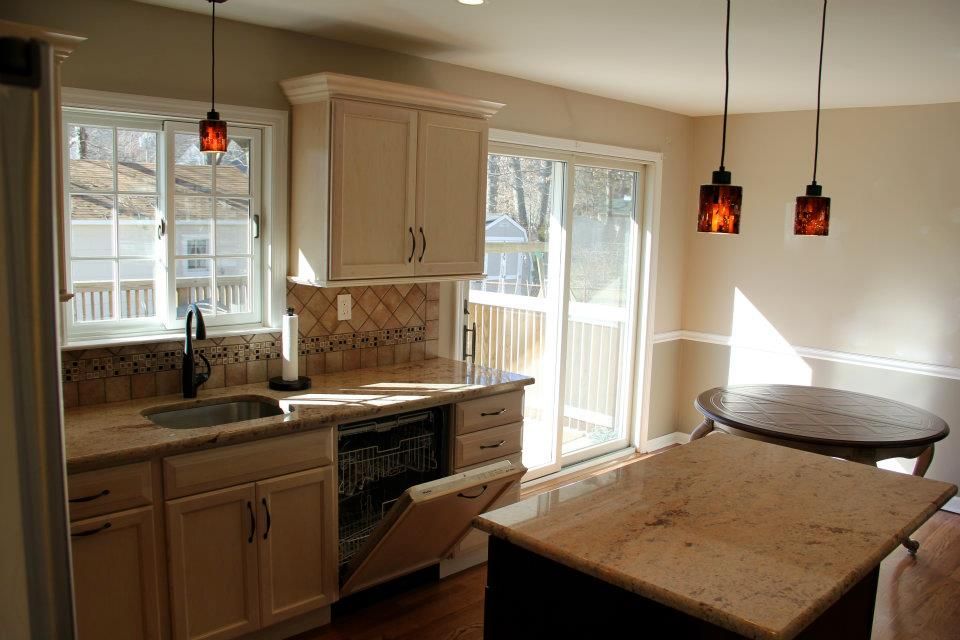 Bathroom with a tub, shower, and window. Neutral-toned tile and a clear glass shower door.