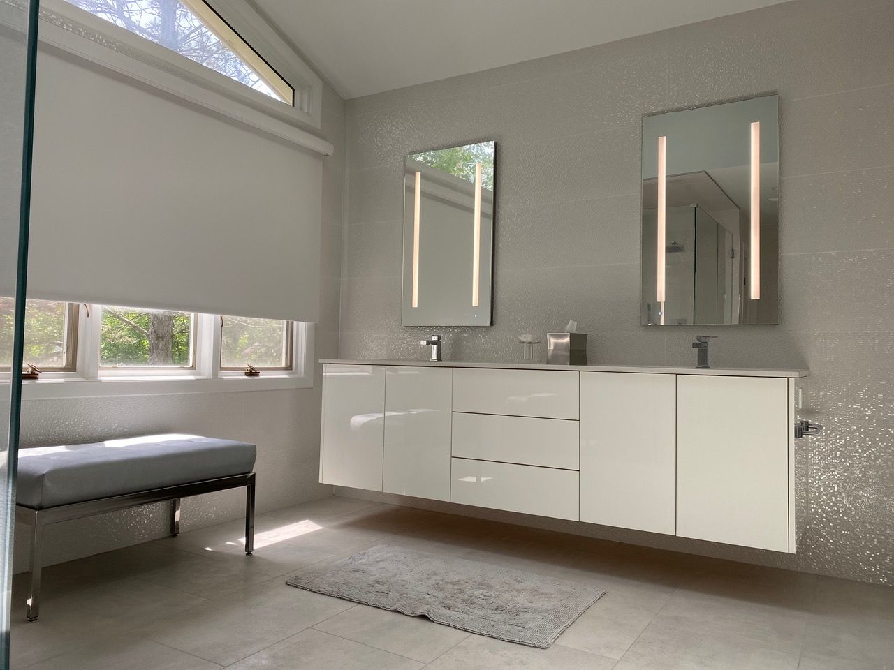 Bathroom with a double sink vanity, large mirror, and neutral colors.