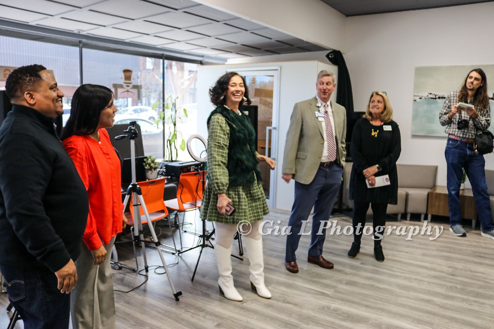 A group of people are standing in a room talking to each other.