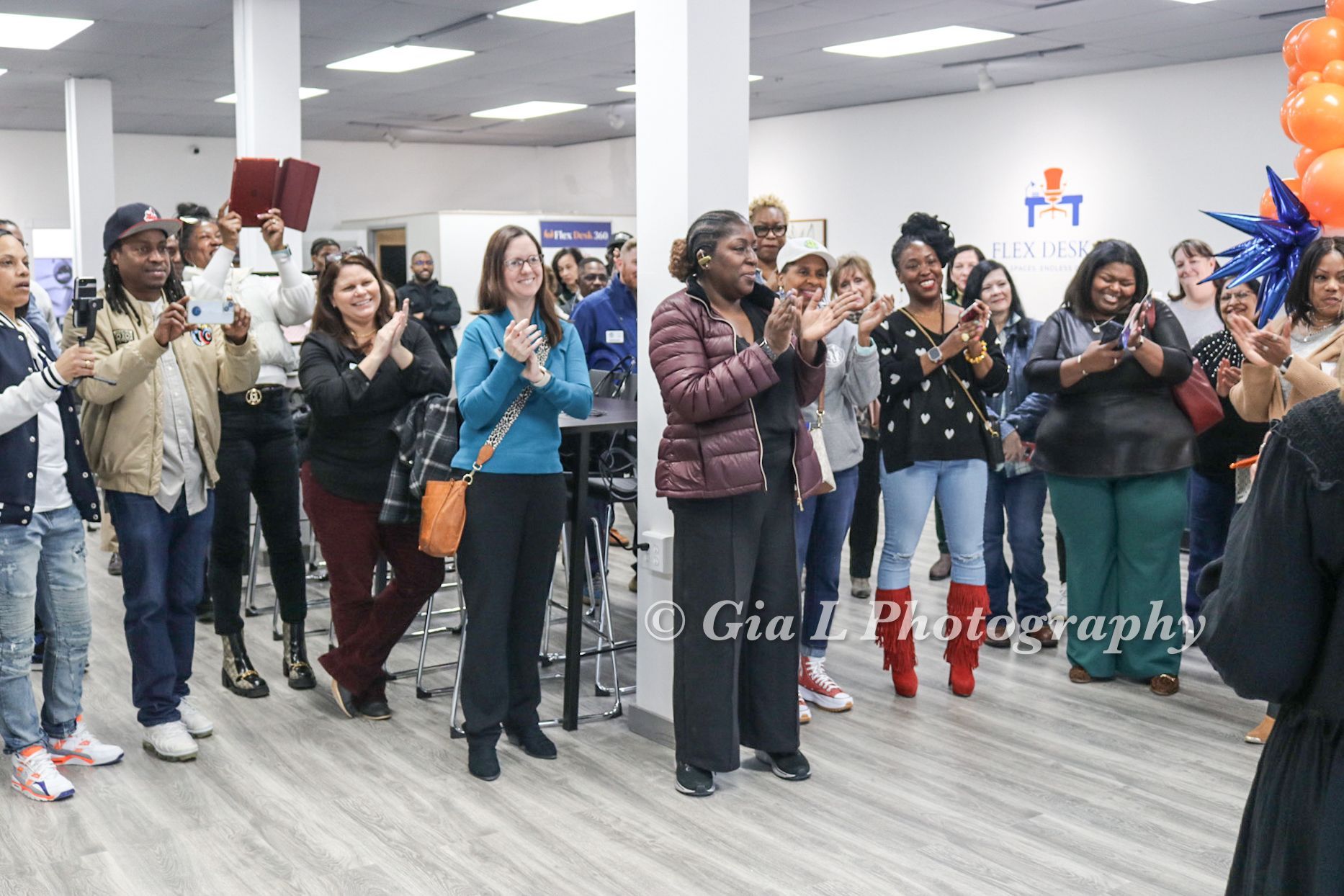 A group of people are standing in a room applauding.