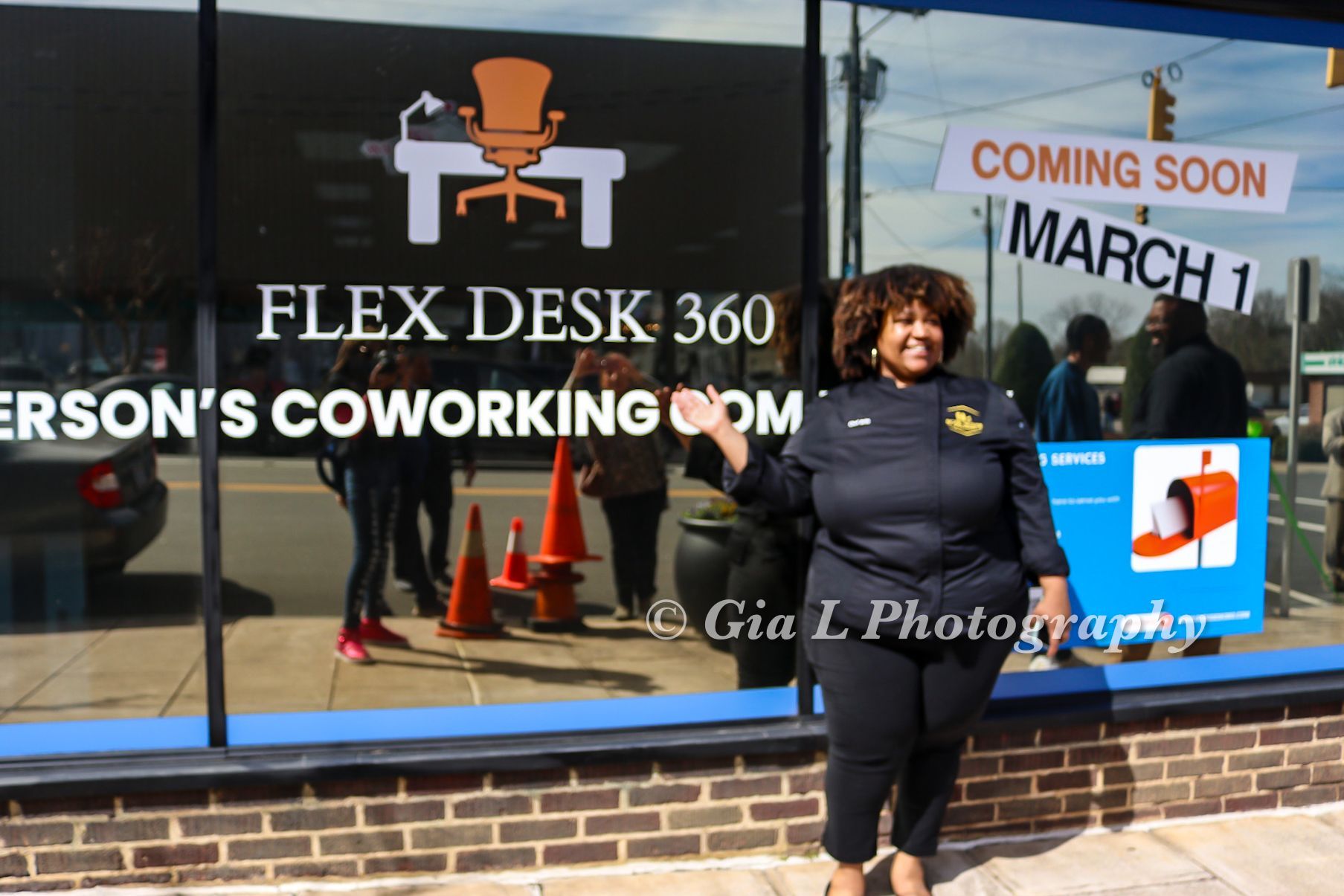 A woman is standing in front of a window that says flex desk 360