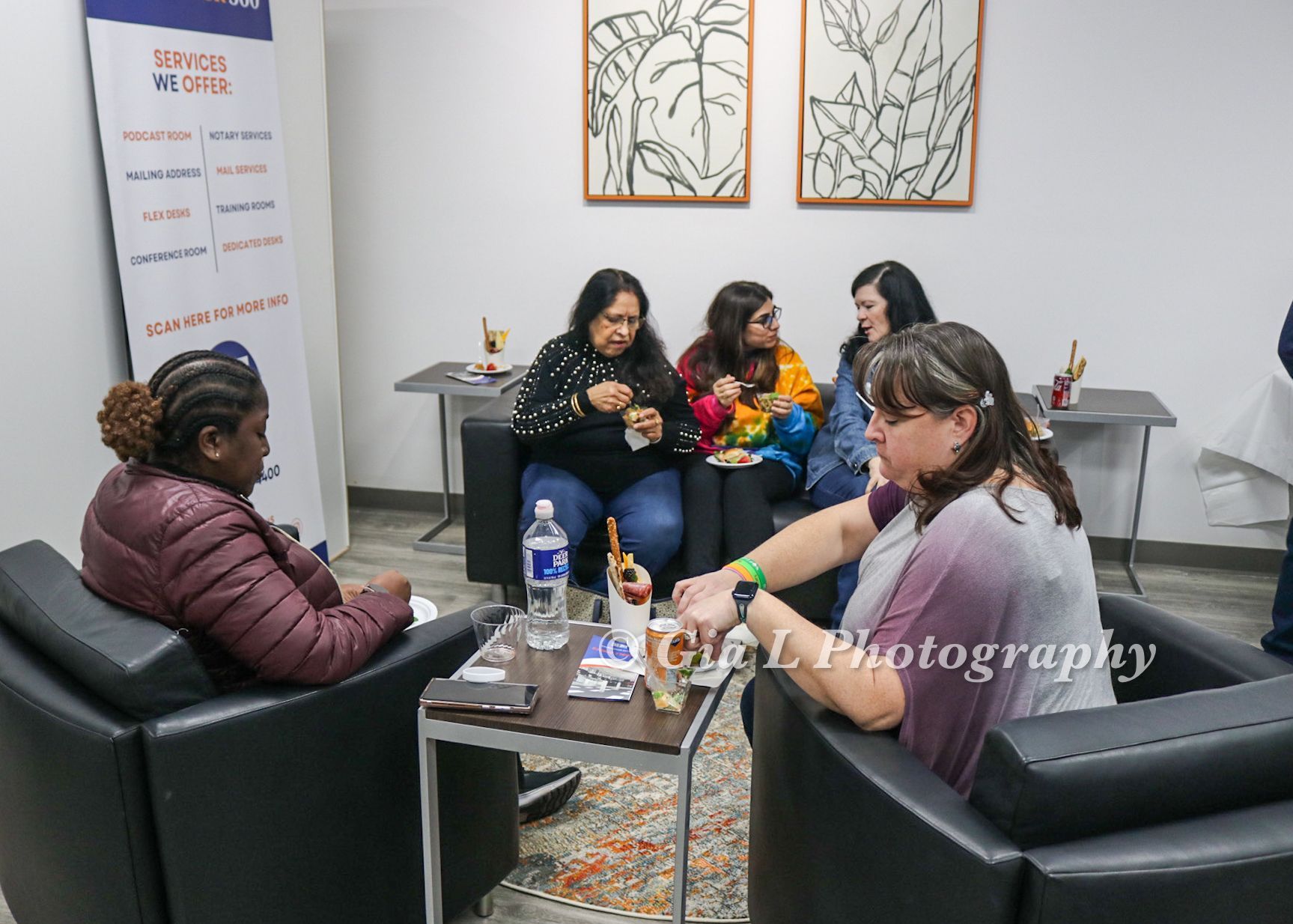 A group of women are sitting around a table in a living room.