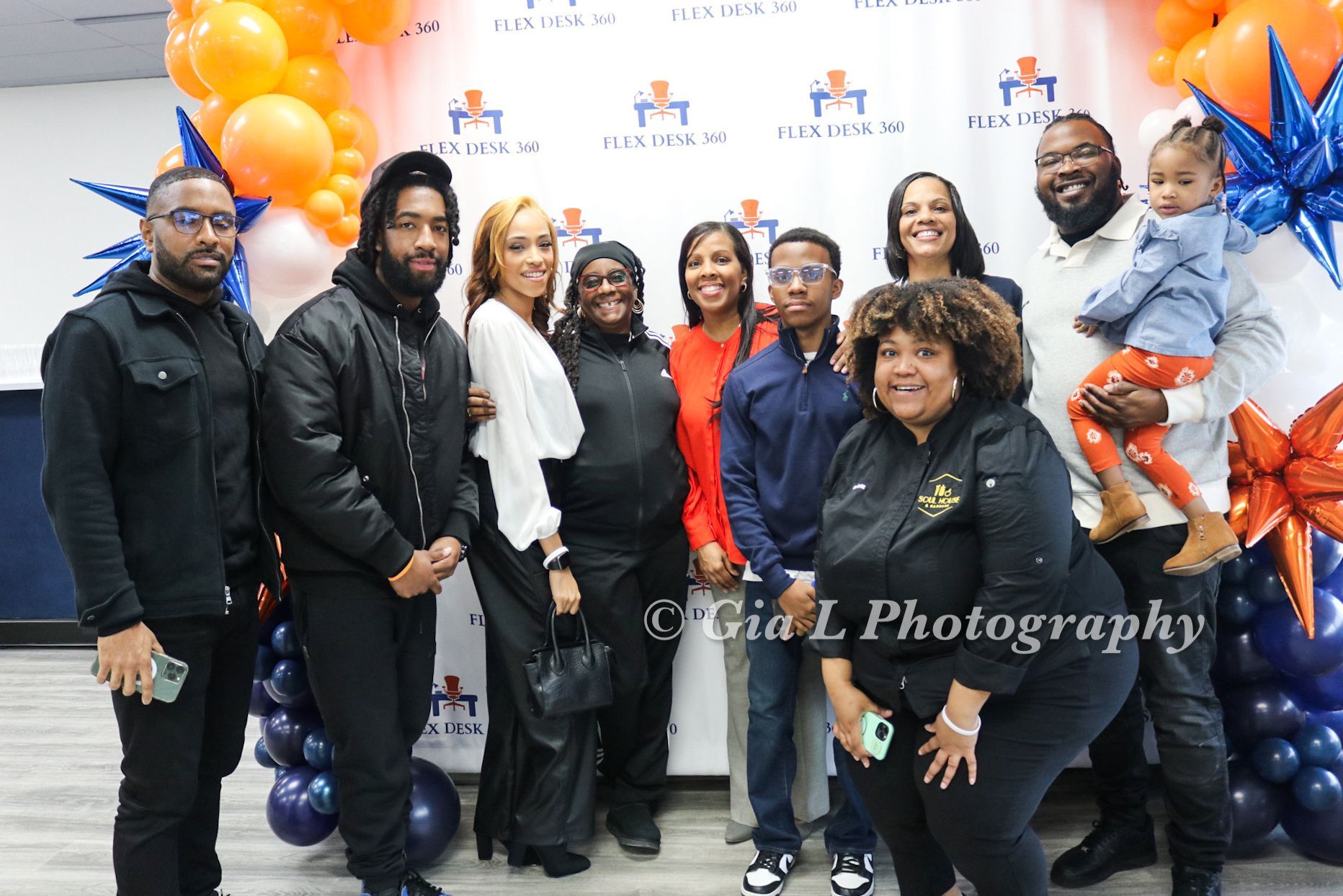 A group of people are posing for a picture in front of balloons.