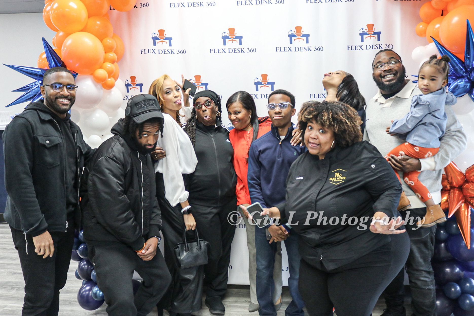 A group of people are posing for a picture in front of balloons.