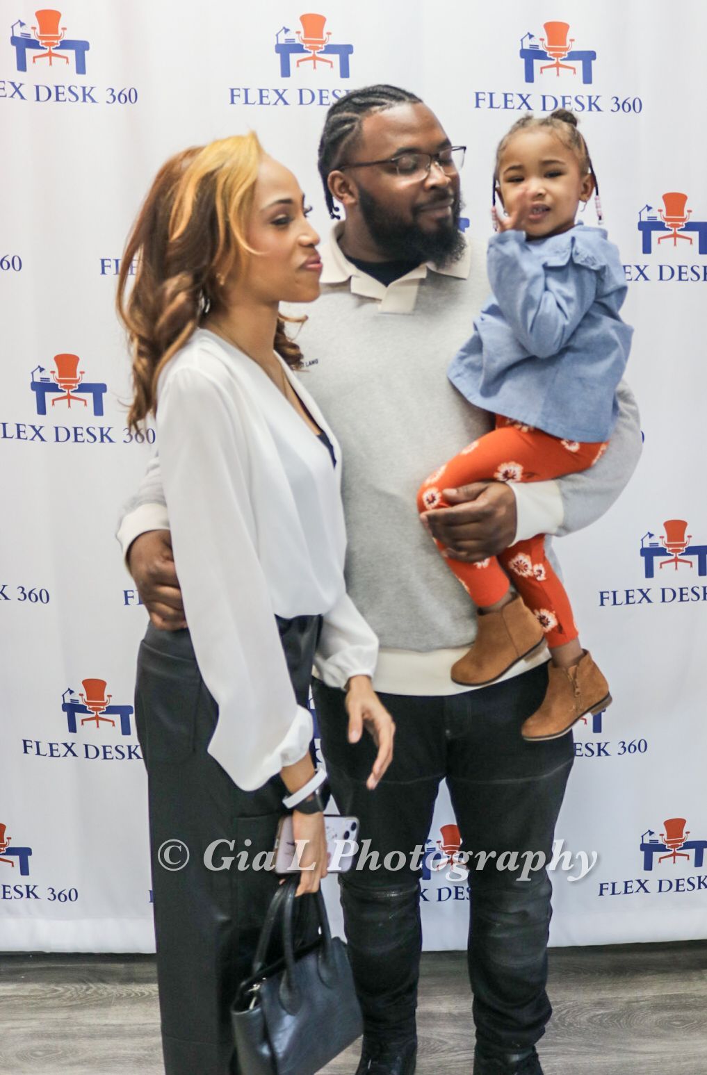 A man and woman are standing next to each other holding a little girl.