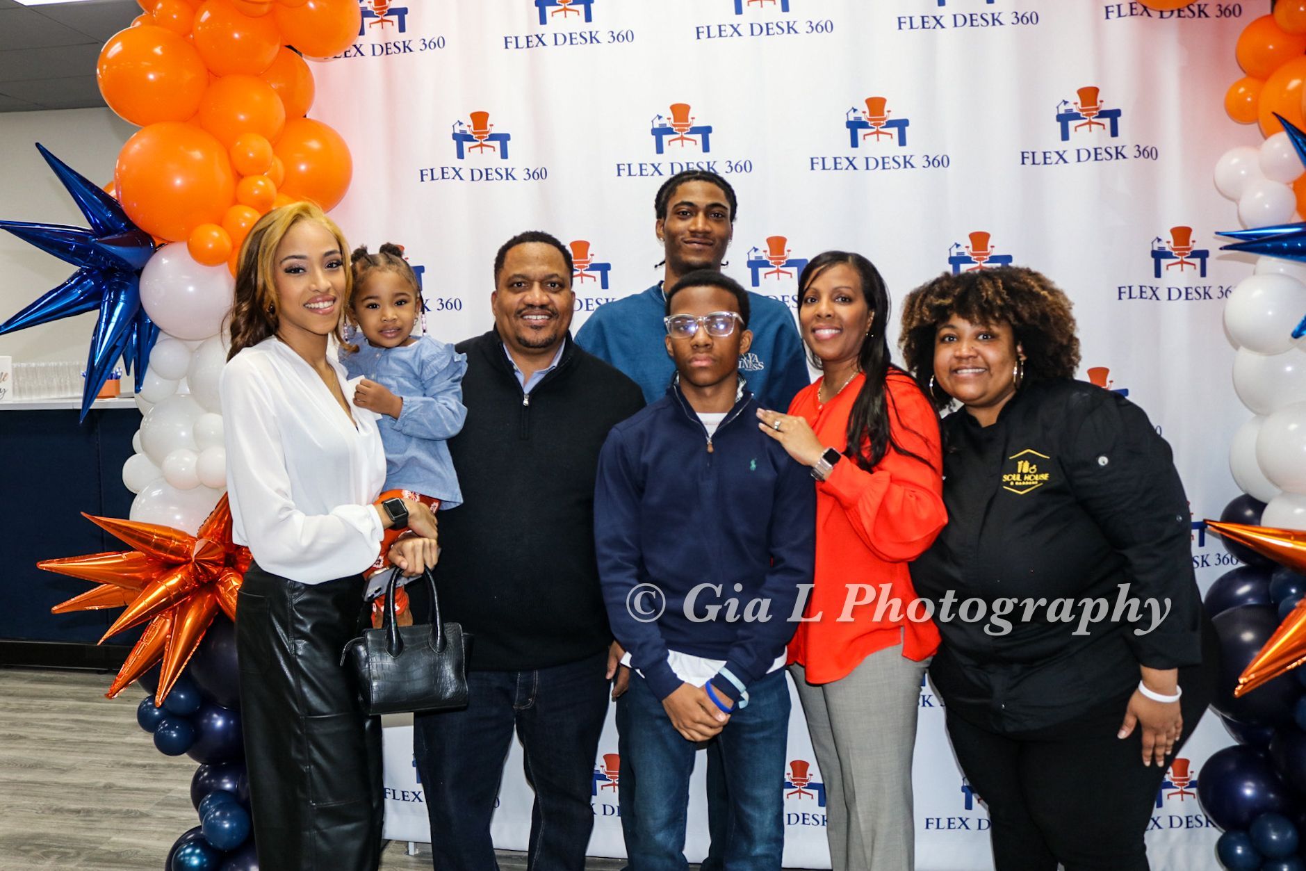 A group of people are posing for a picture in front of balloons.
