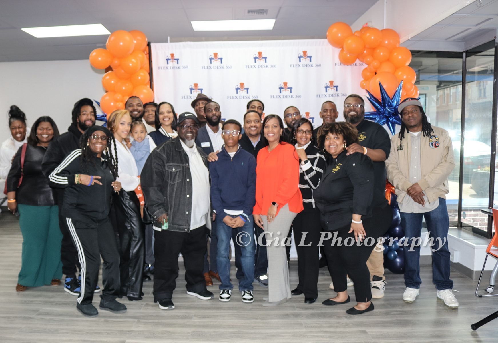 A group of people are posing for a picture in front of balloons.