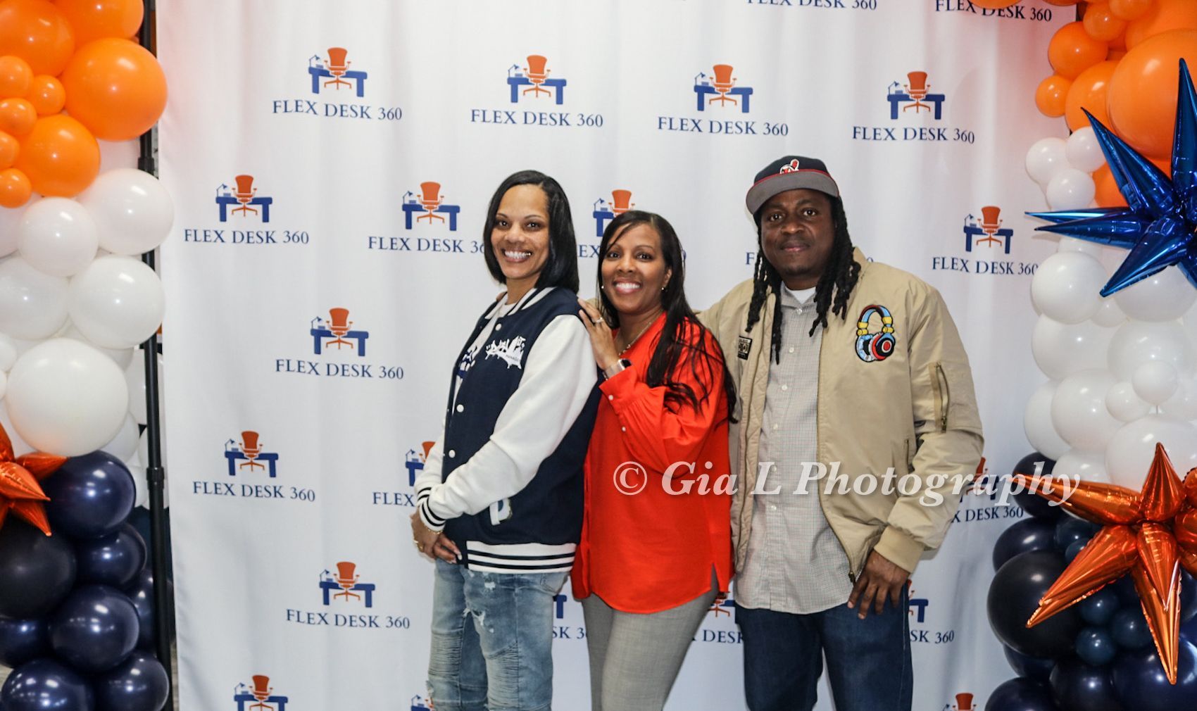 A group of people are posing for a picture in front of balloons.