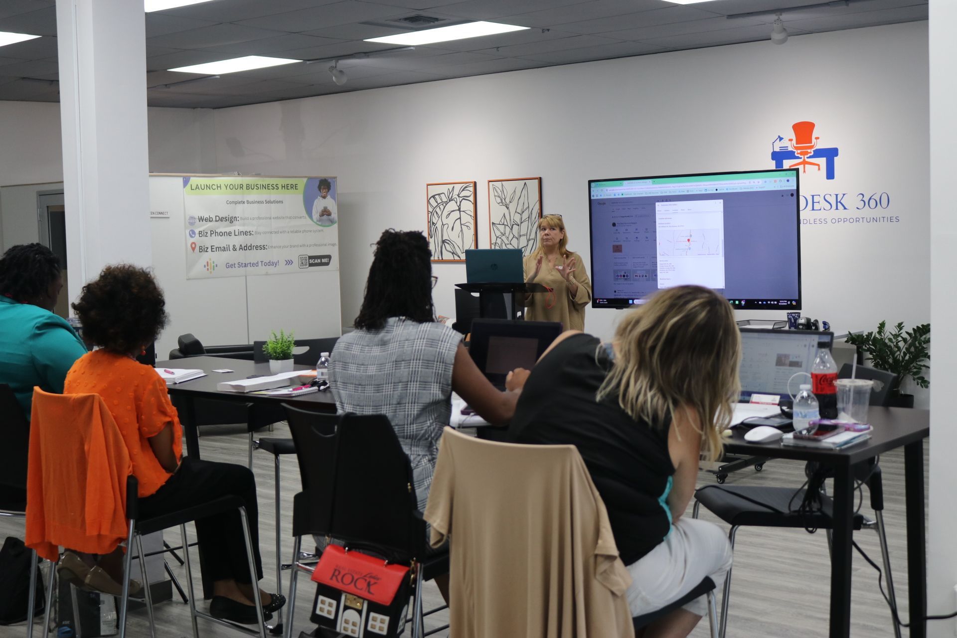 A woman is giving a presentation to a group of people in a room.
