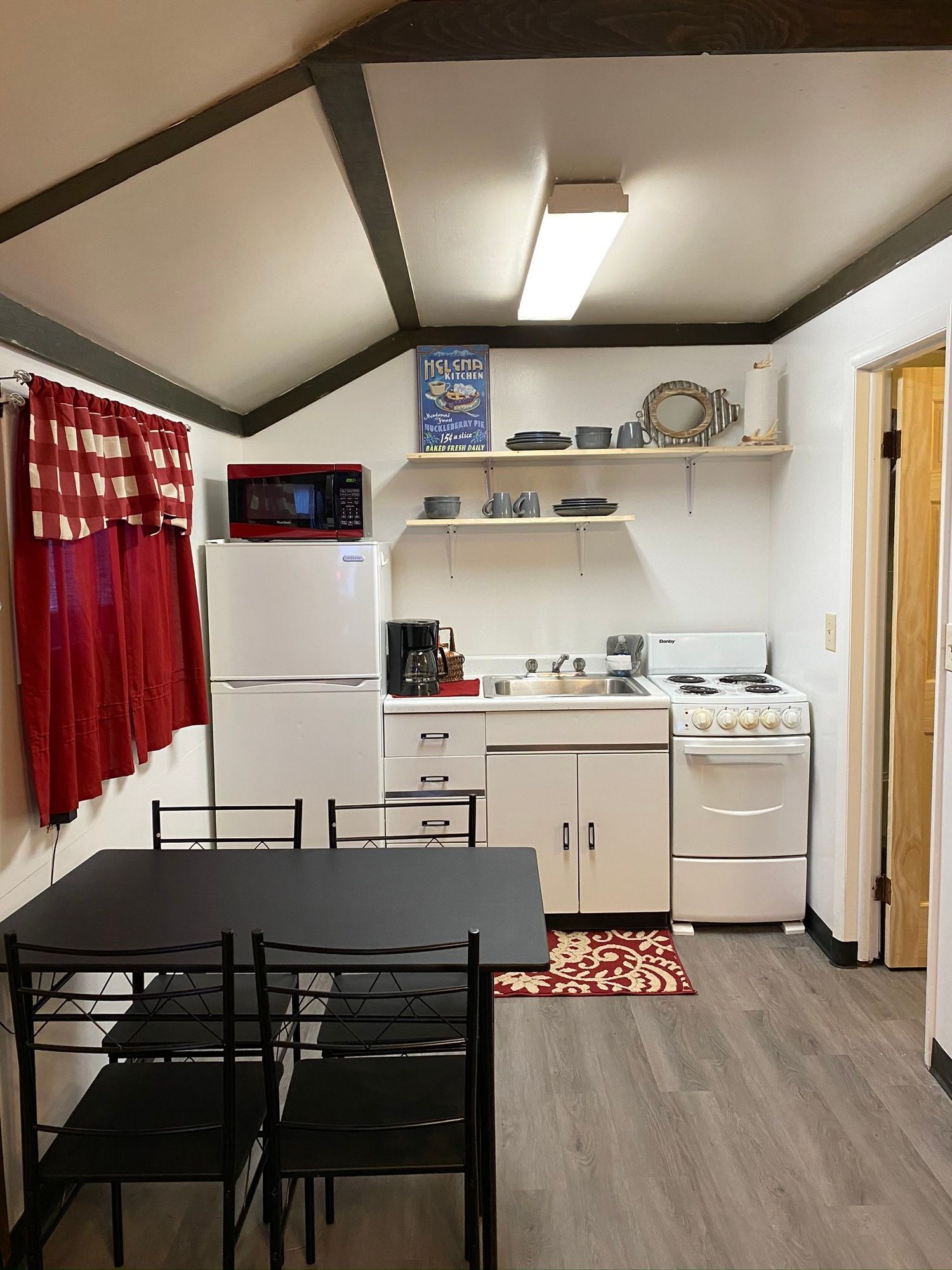 A kitchen with a table and chairs and a refrigerator