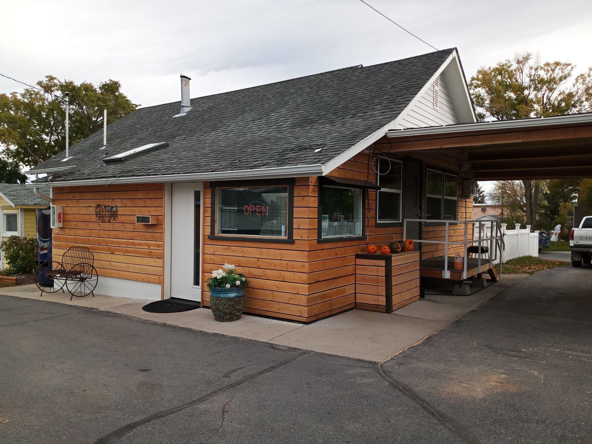 A small brick house with a carport in front of it.