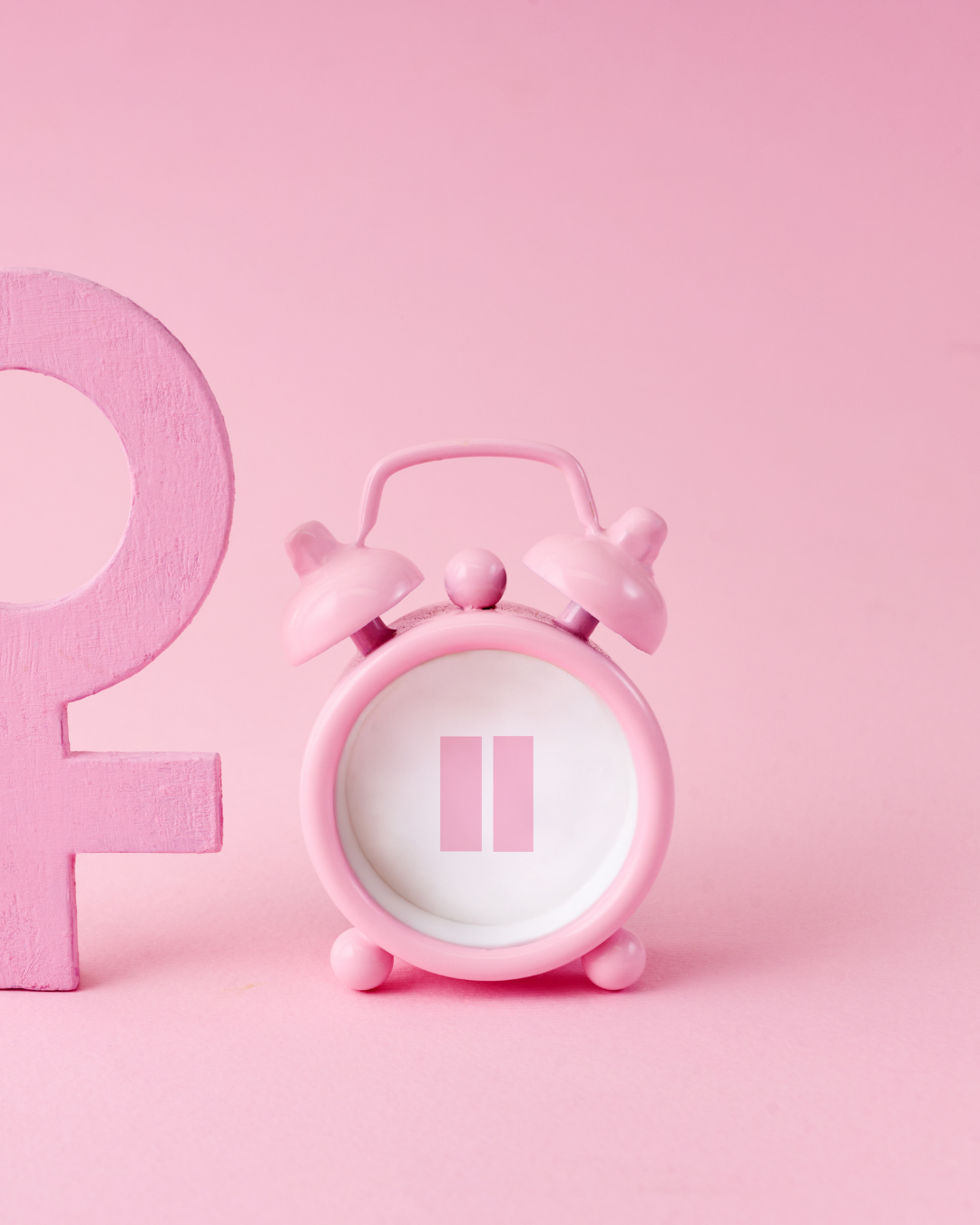 Pink alarm clock with pause symbol on a pink background beside a female sign
