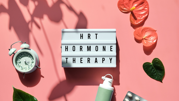 HRT hormone therapy lightbox with pills, clock, and leaves on pink background