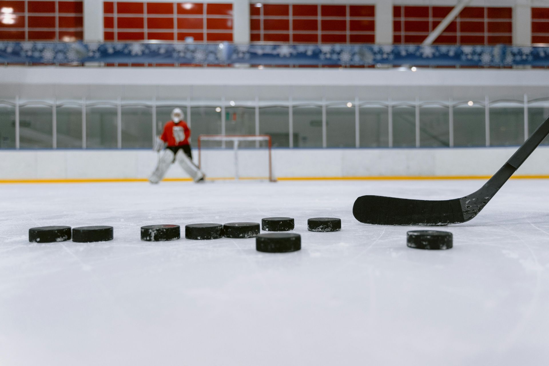Ein Hockeyspieler mit Pucks vor dem Tor