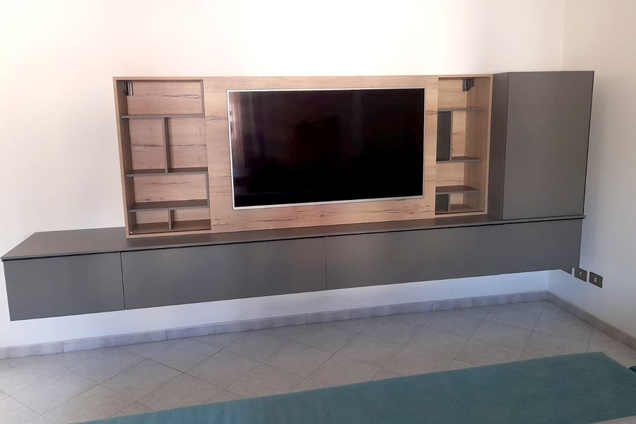 Una TV a schermo piatto è montata su una parete del soggiorno.