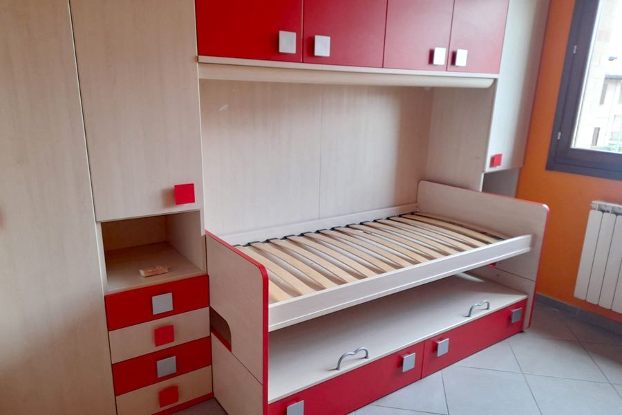 Una camera da letto con mobili rossi e bianchi e un letto