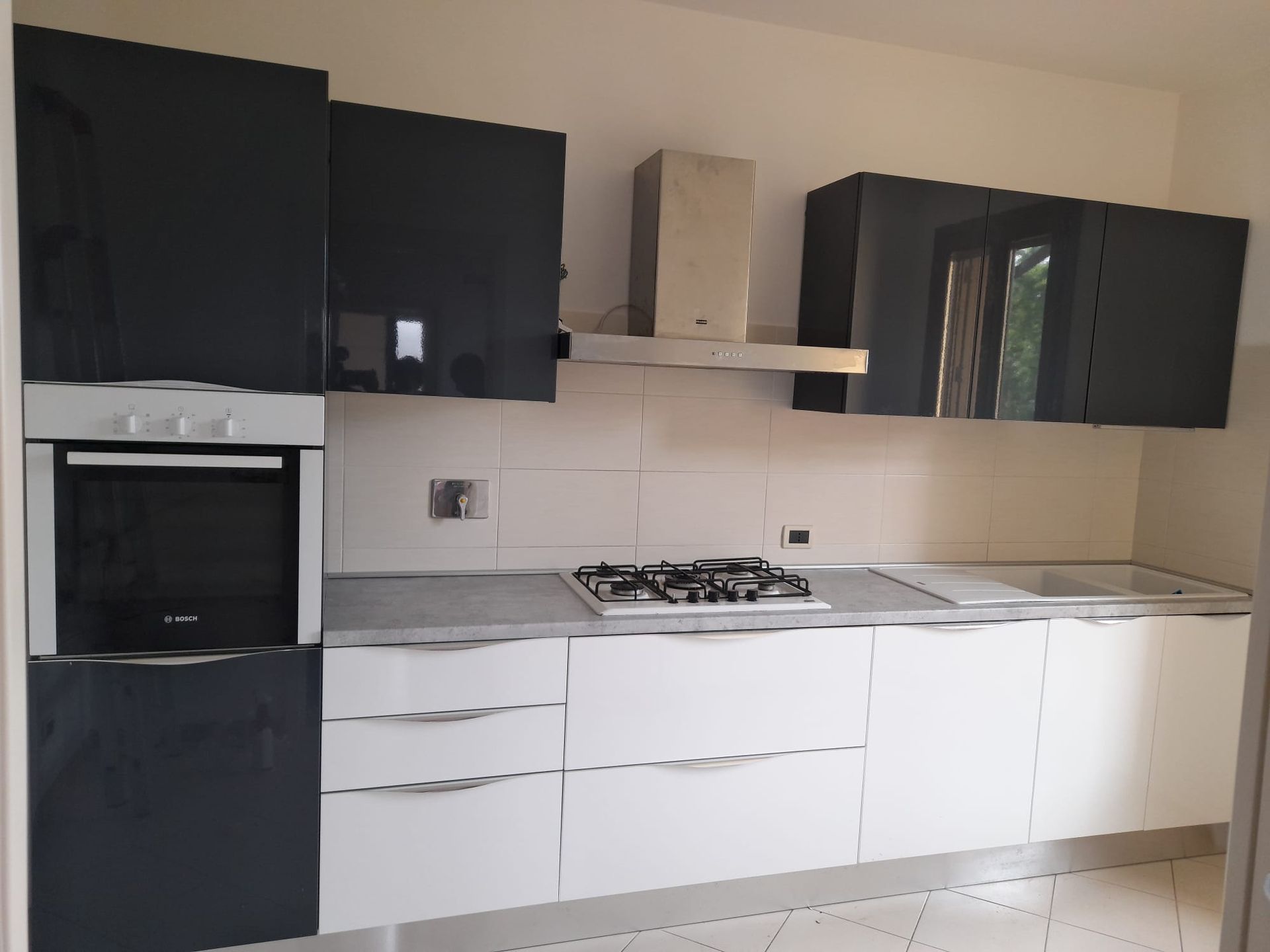 Una cucina con mobili neri e cassetti bianchi