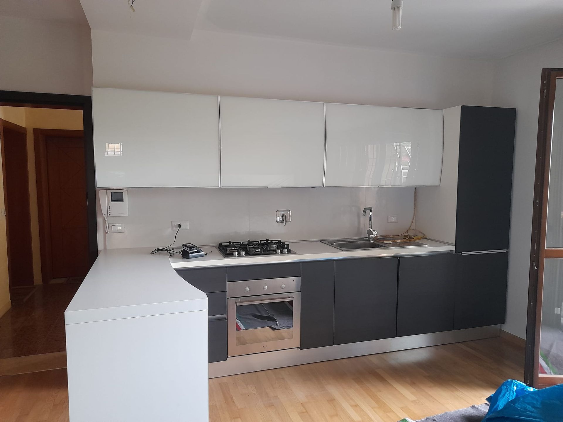 Una cucina con mobili bianchi e neri e un forno con fornelli.