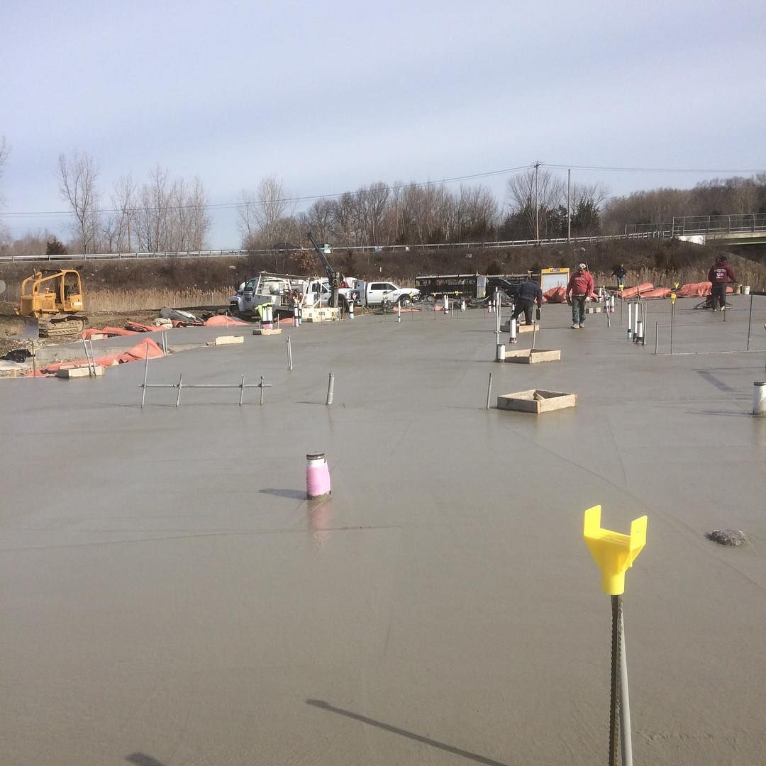 A group of people are working on a concrete floor.