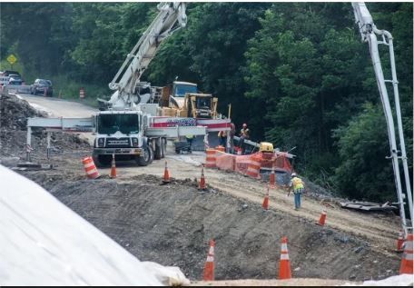 A construction site with a truck and a concrete pump