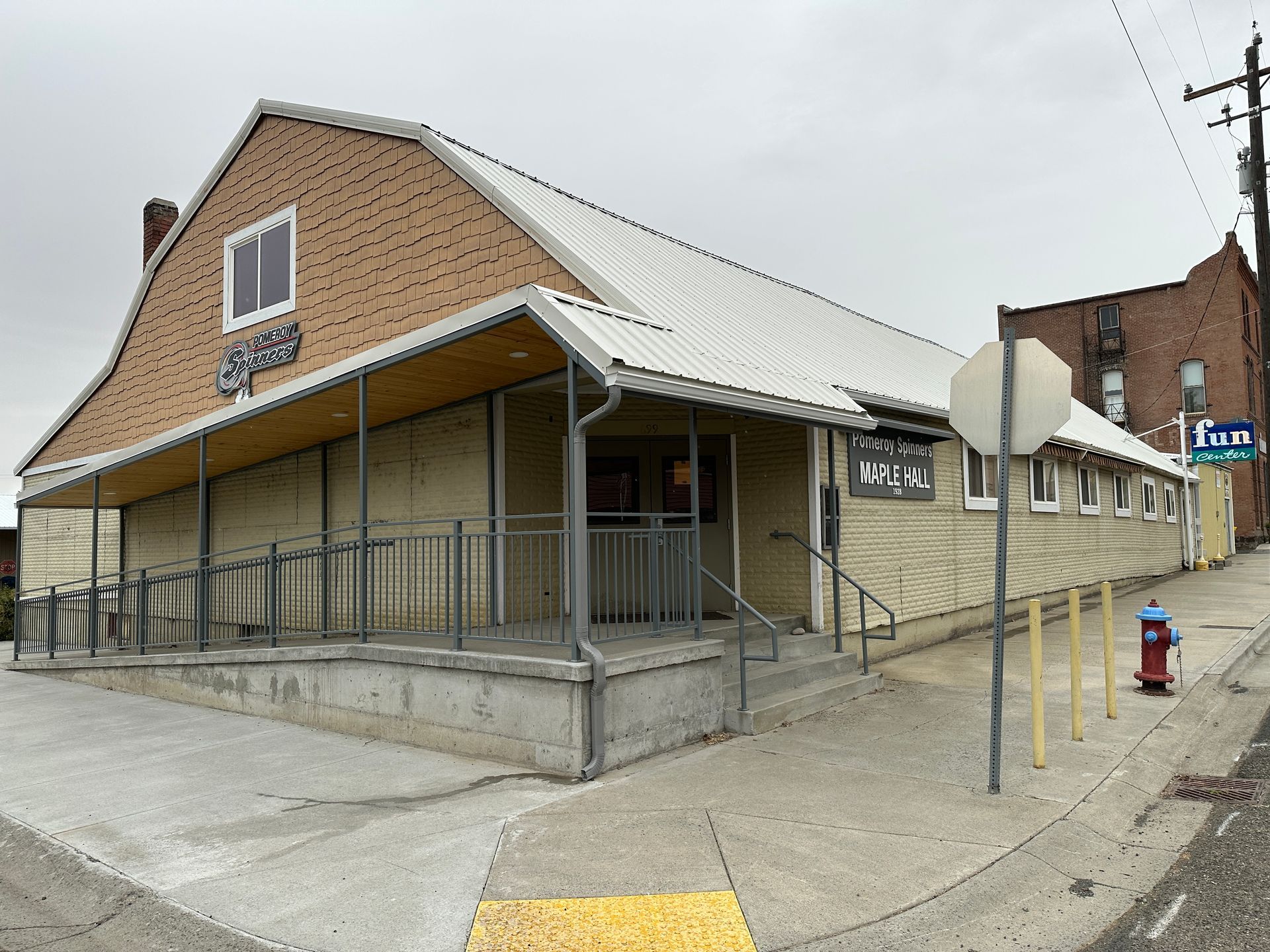 Exterior of a single-story building with a wheelchair ramp and awning; red fire hydrant on the sidewalk.