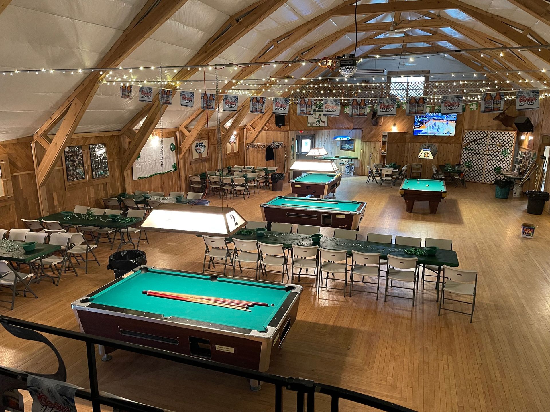 High-angle view of a large wood-paneled room with multiple pool