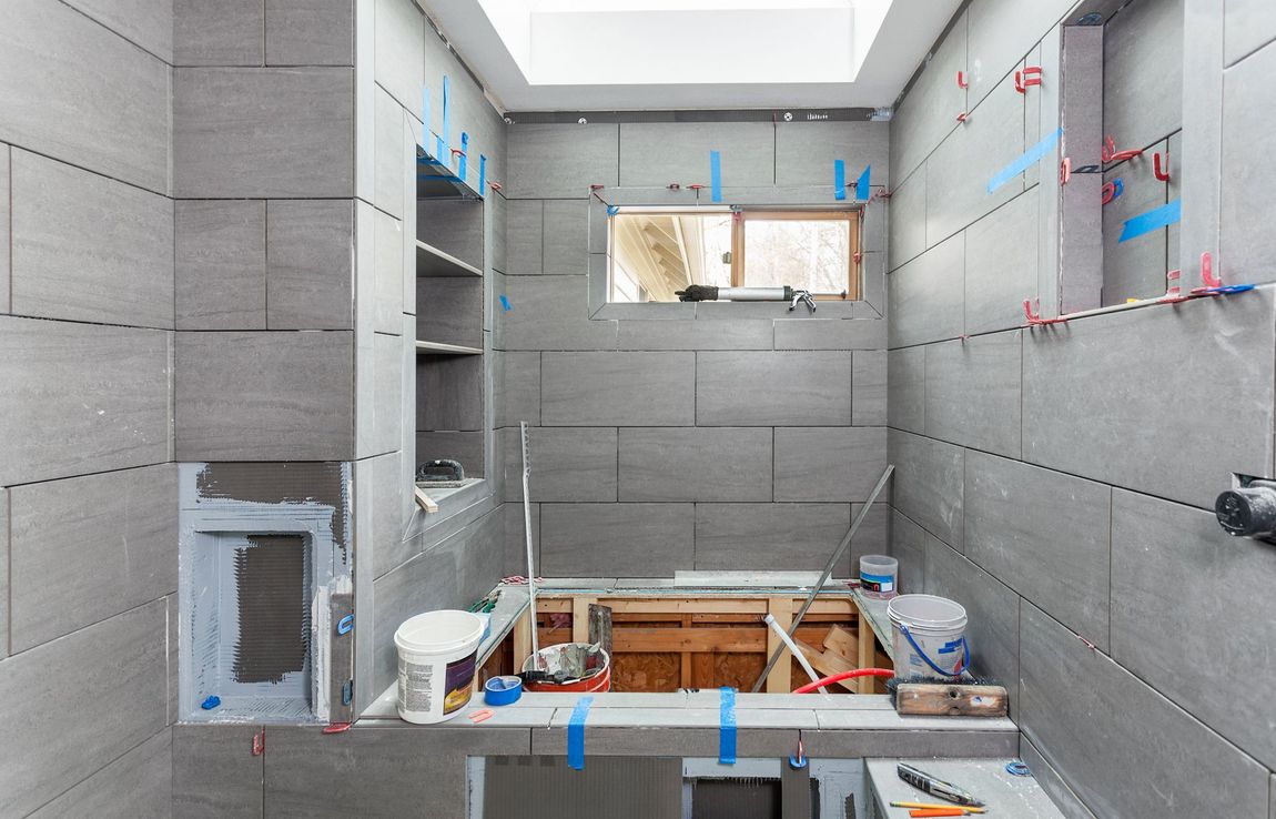 A bathroom under construction with a window and a sink.