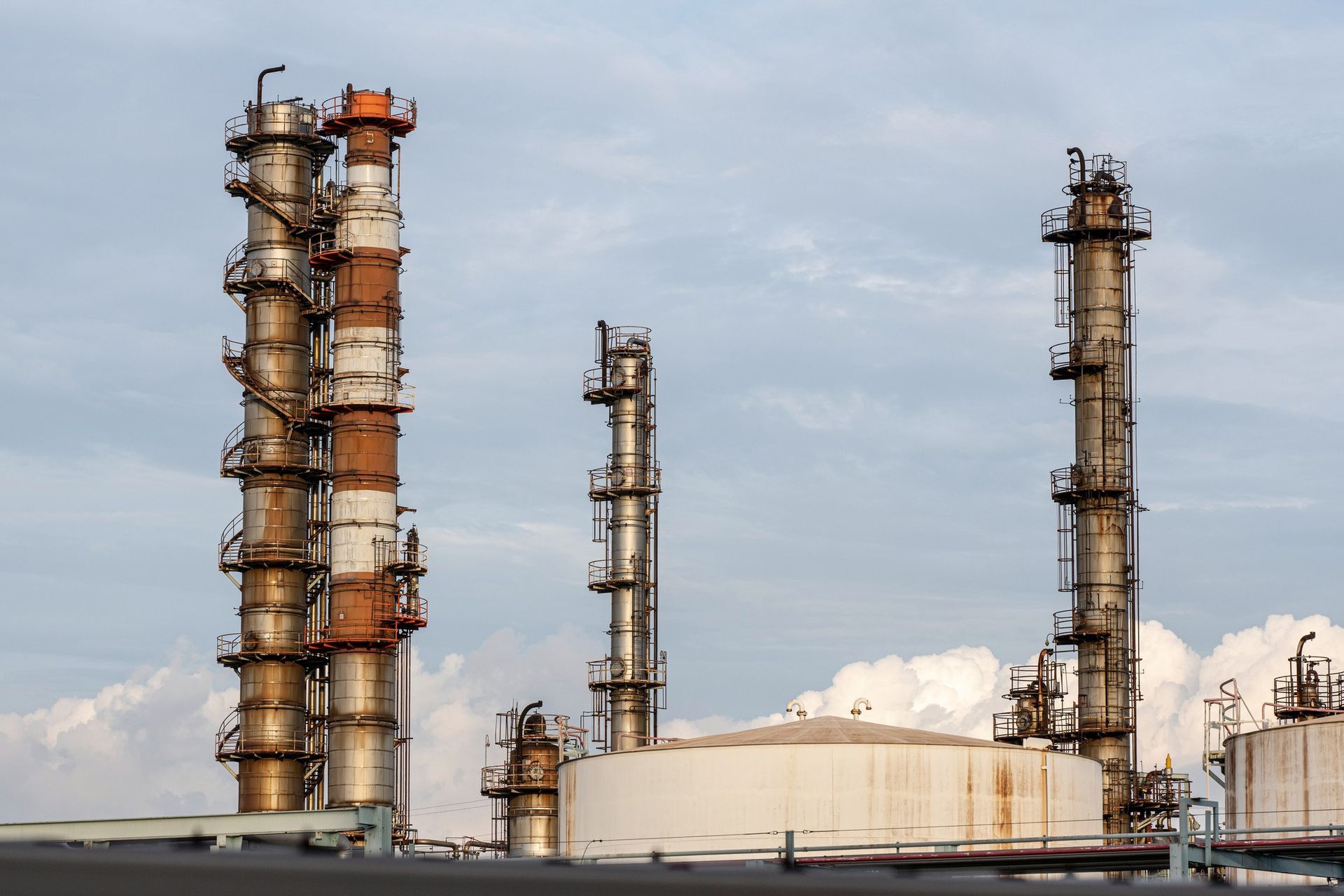 A large oil refinery with a lot of smoke coming out of the chimneys.