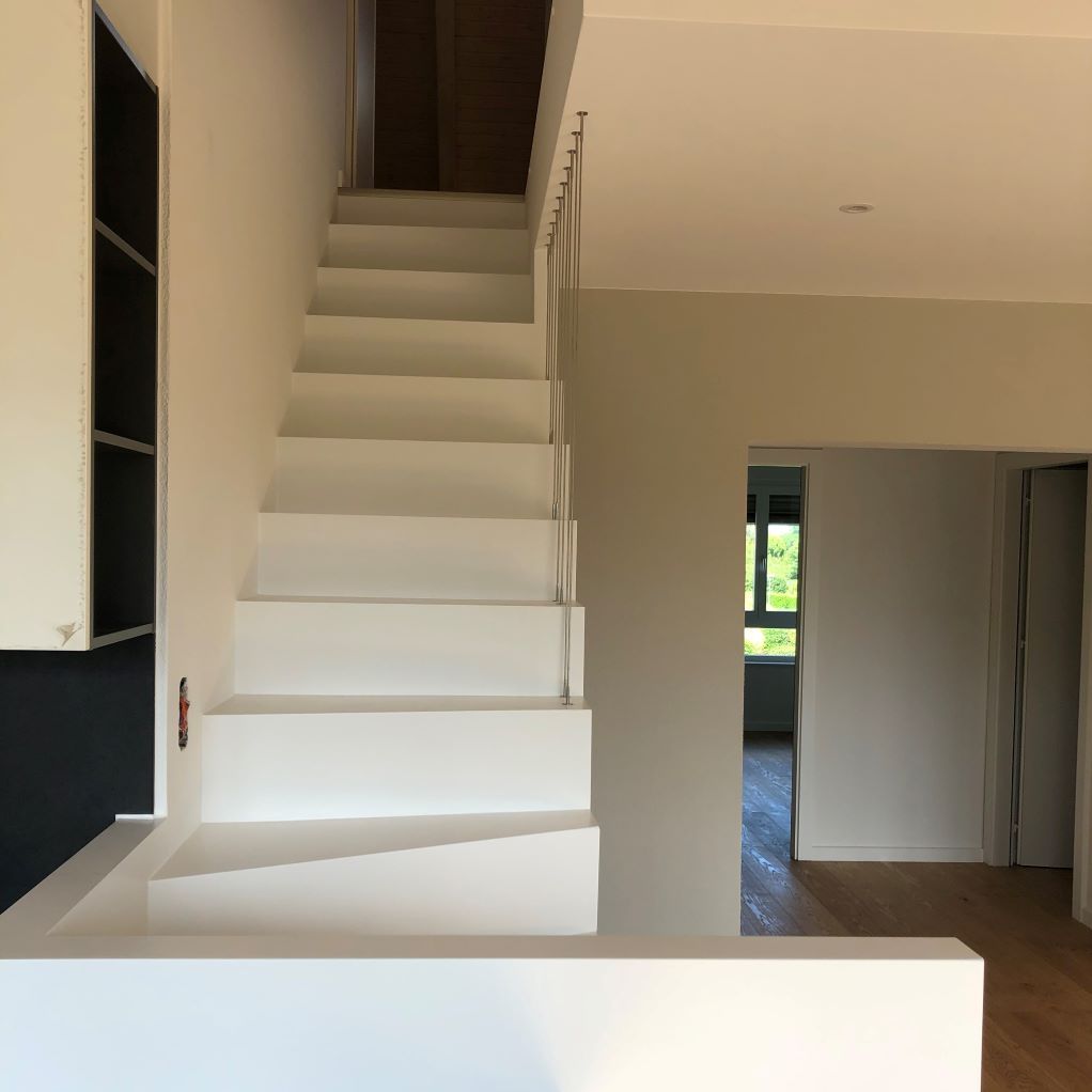 Un escalier blanc menant au deuxième étage d'une maison