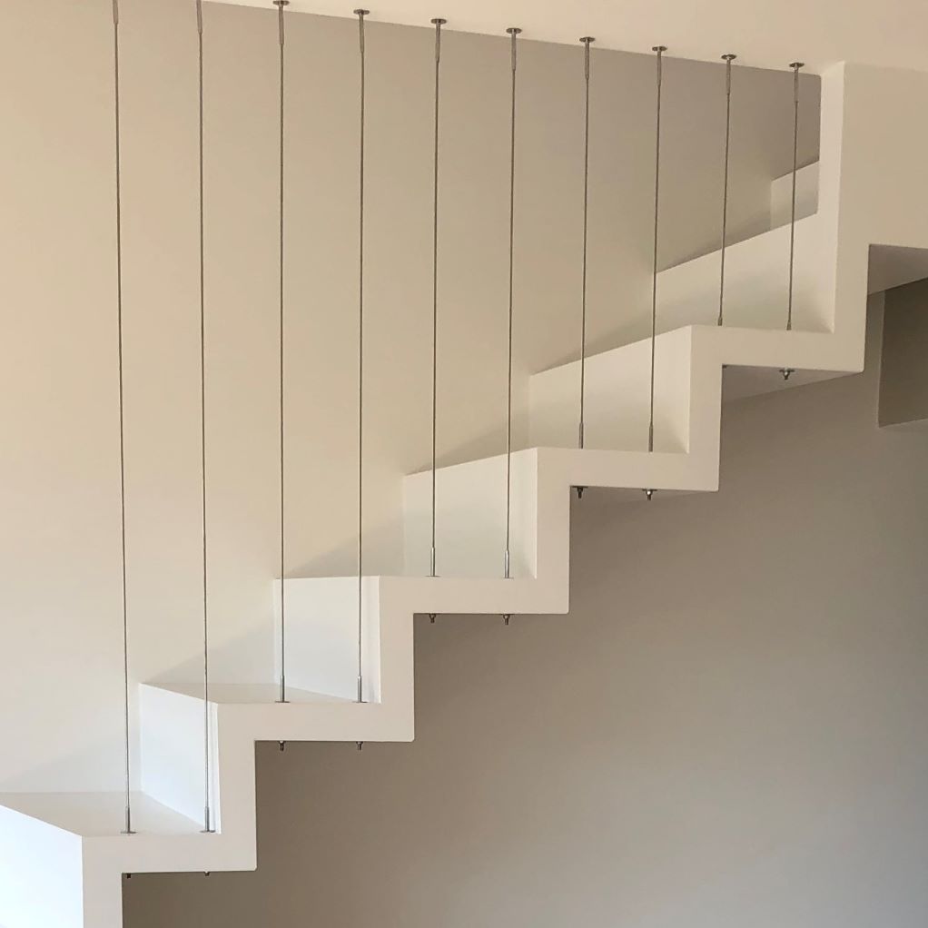 Un escalier blanc avec une rampe en acier inoxydable