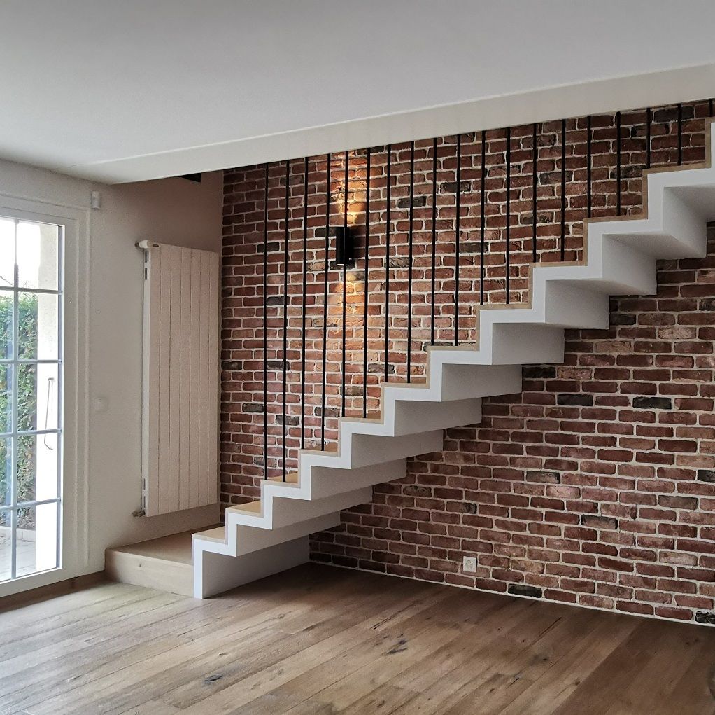 Un escalier dans une pièce avec un mur de briques