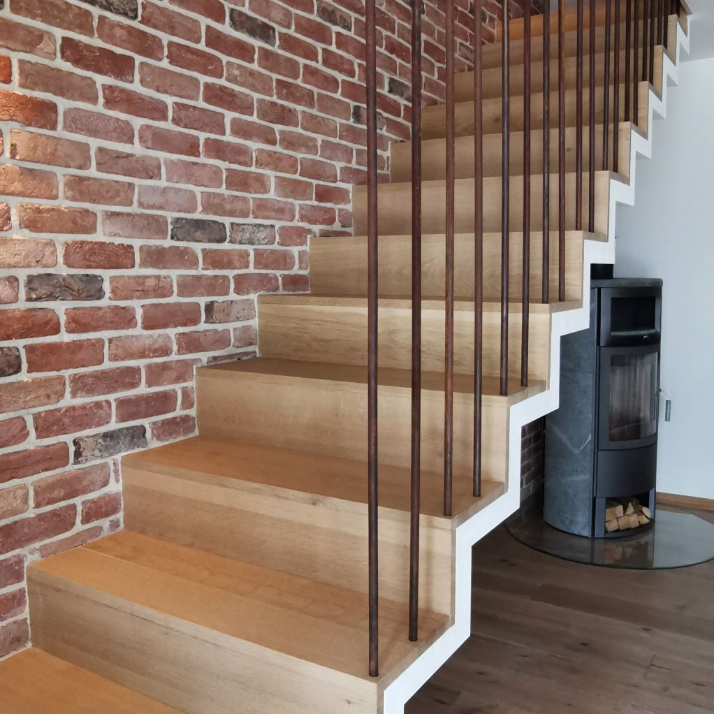 Un escalier en bois avec un mur de briques derrière