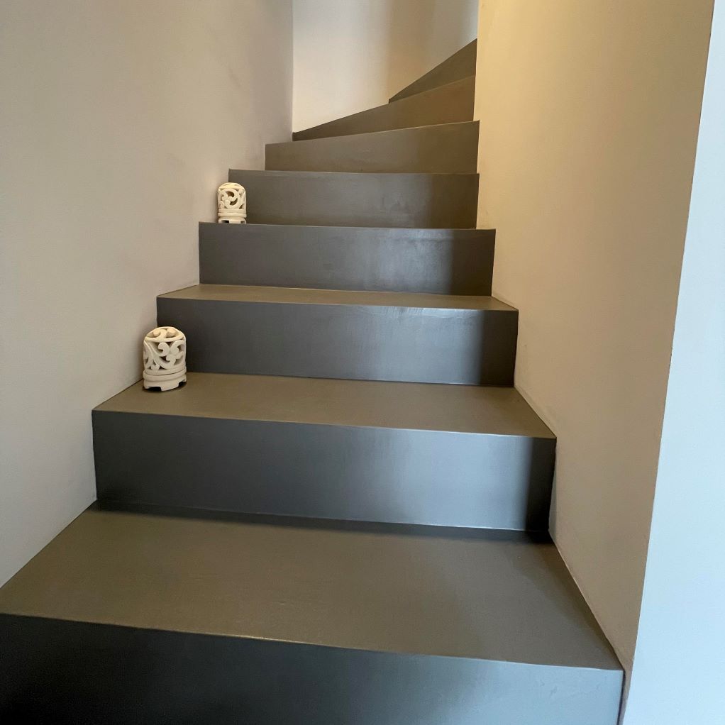 Un escalier avec une statue sur la marche inférieure