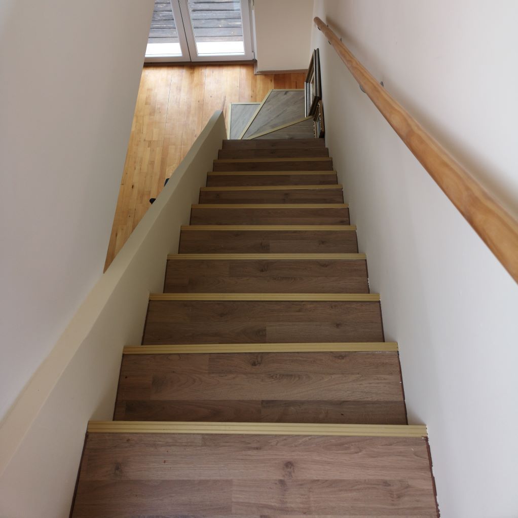 Un escalier en bois avec une rampe en bois