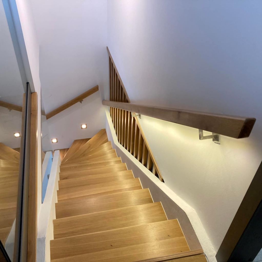 Un escalier en bois avec une rampe blanche