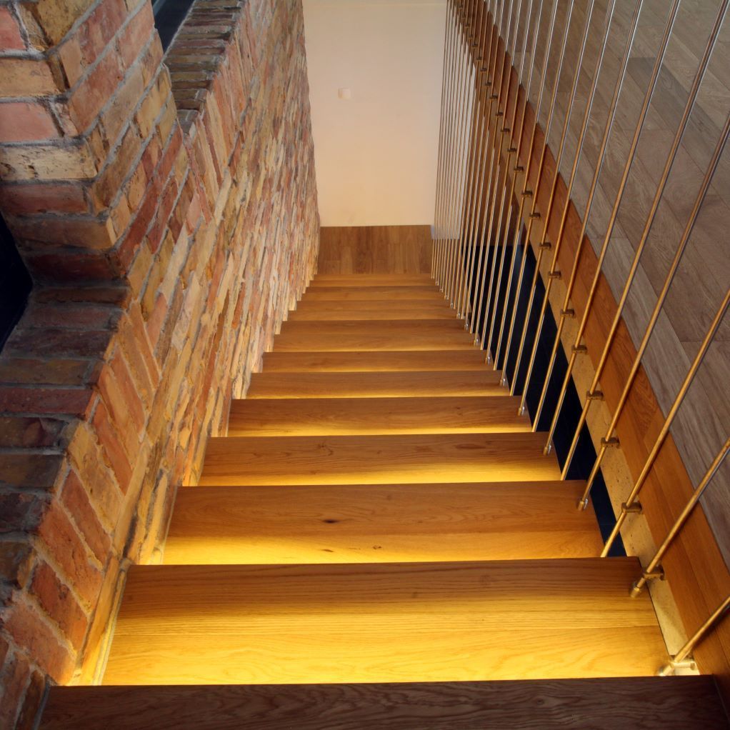 Un escalier en bois avec un mur de briques derrière