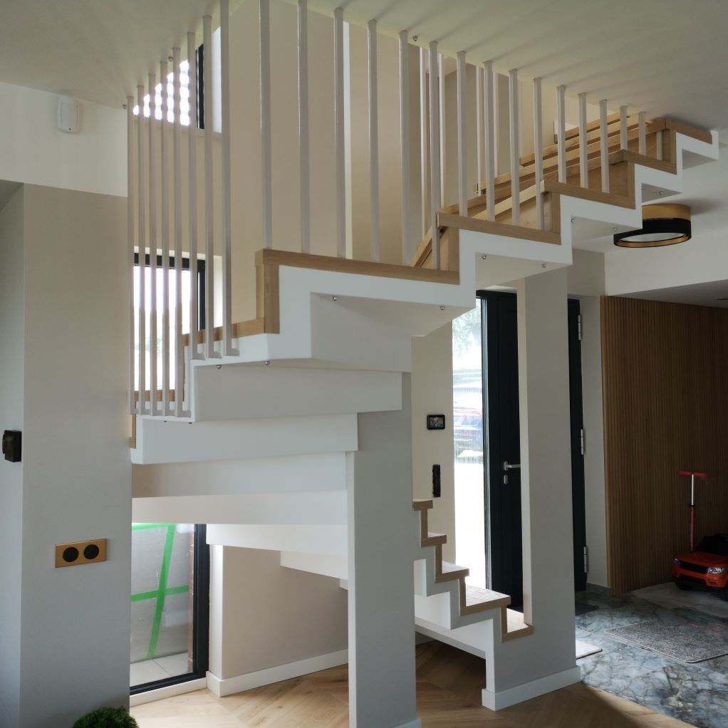 Un escalier blanc avec une rampe en bois dans une pièce