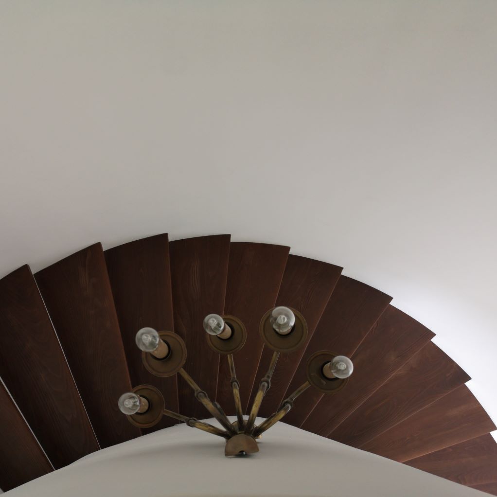 Un escalier en bois en forme d'éventail avec des lumières sur les marches