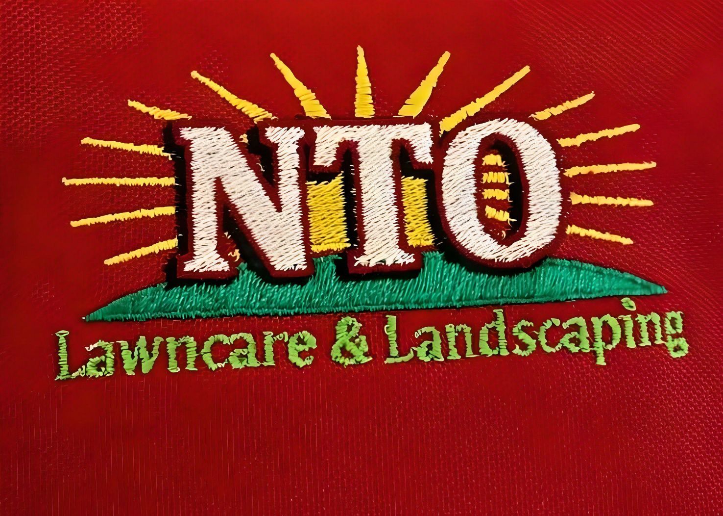 A nto lawn care and landscaping logo on a red shirt