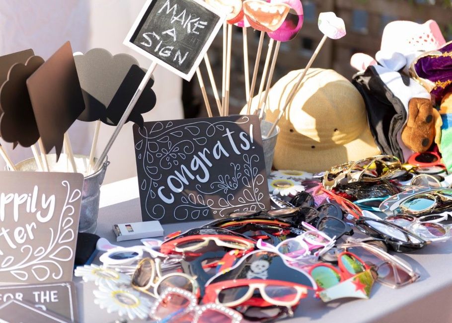 Display of colorful sunglasses and signs reading “Congrats!” at an outdoor market booth