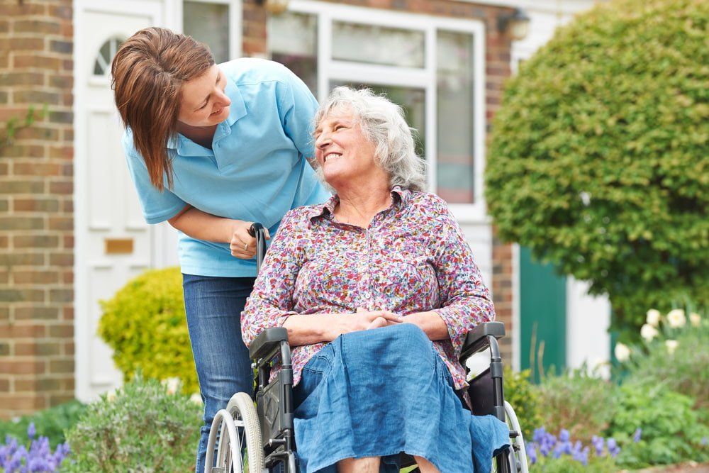 Carer With Senior Woman In Wheelchair — NDIS Services in Yeppoon, QLD
