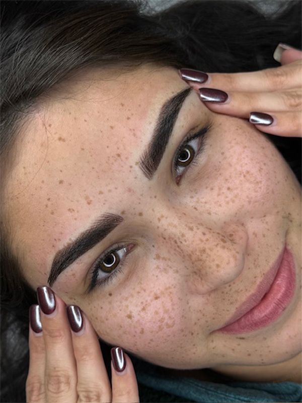 Hands in black gloves stir contents in a small white cup with a white-handled tool.
